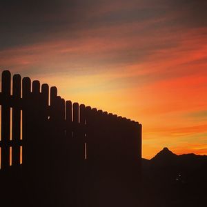 Silhouette buildings against sky during sunset