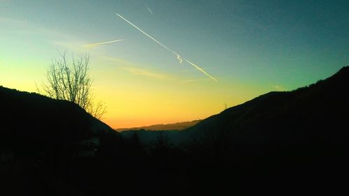 Silhouette landscape against sky at sunset