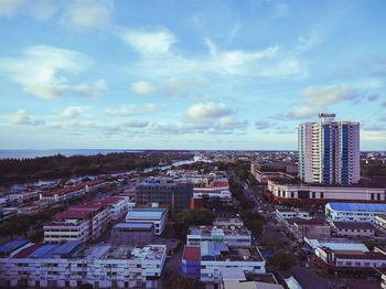 View of cityscape against cloudy sky