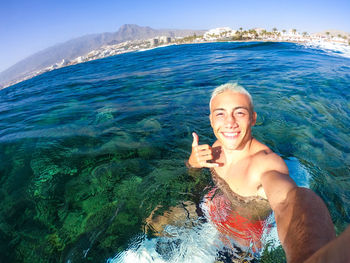 Portrait of smiling teenage boy enjoying ride in jet boat in sea