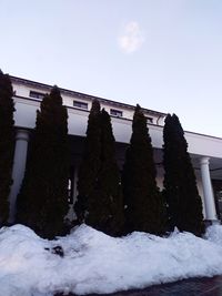 Low angle view of snow covered building against sky