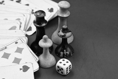 High angle view of chess pieces with dice and playing cards on table