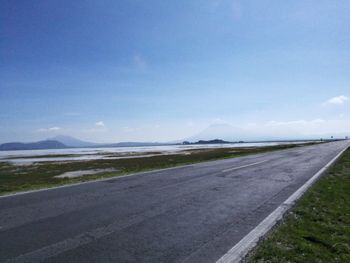 Scenic view of road by landscape against sky