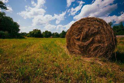 Hay bales on field against sky