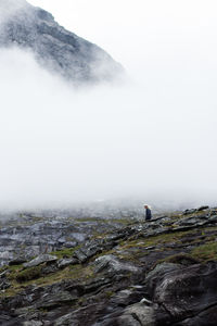 Scenic view of person on mountain against sky