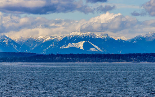 A view of elliott bay with the olympic mountain range in the distance.