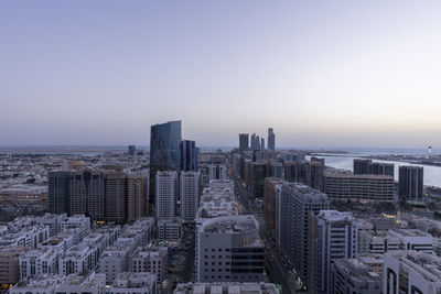 Aerial view of buildings in city against clear sky