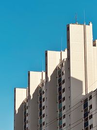 Low angle view of buildings against clear blue sky