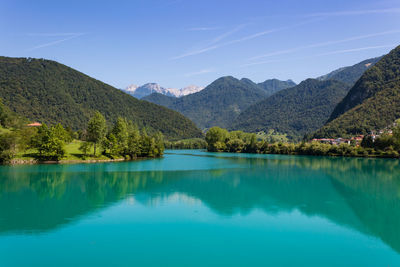 Scenic view of lake and mountains against clear blue sky