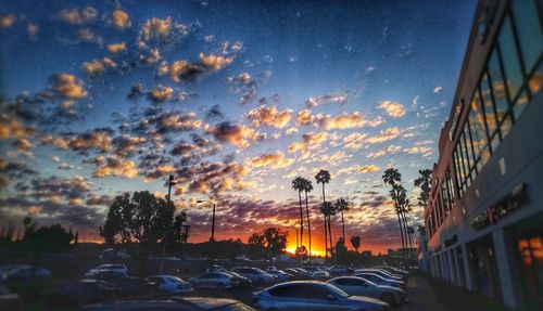 Cars on road against sky during sunset