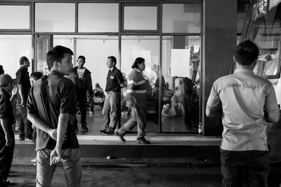 Rear view of people standing in front of building