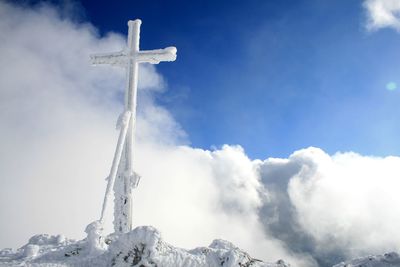 Low angle view of cross against sky