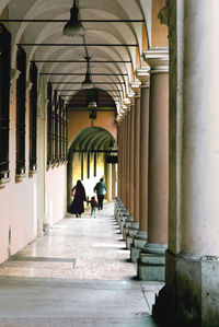 Rear view of people walking in corridor of building