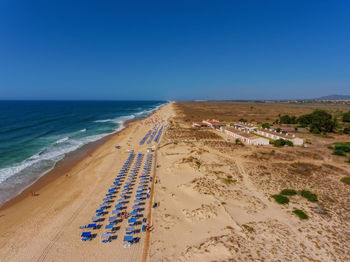 Scenic view of beach against clear blue sky