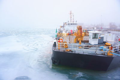 Ship moored at harbor against clear sky