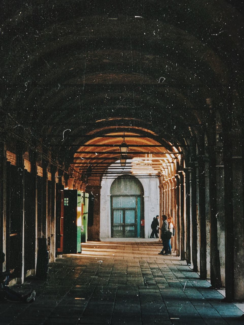 MAN WALKING IN BUILDING CORRIDOR