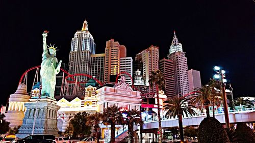 Low angle view of illuminated buildings against sky at night