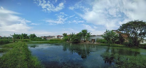 Scenic view of lake by building against sky