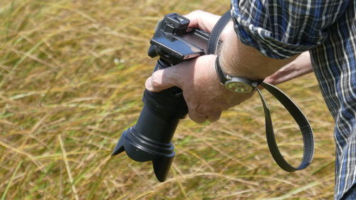 Midsection of man photographing field