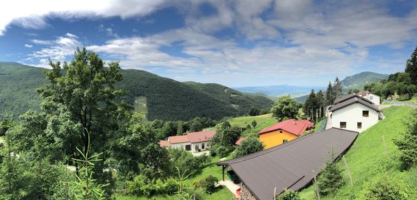 Houses amidst trees and buildings against sky