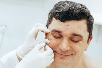 Cropped hand of cosmetologist treating patient