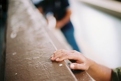 Close-up of hand on wood