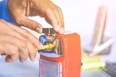 Cropped hands of businessman using pencil sharpener