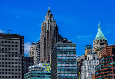 Buildings in city against blue sky