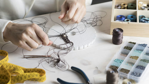 High angle view of woman working with thread on table