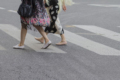 Low section of woman walking on road