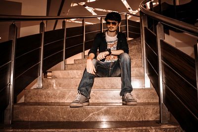 Full length of young man sitting on staircase