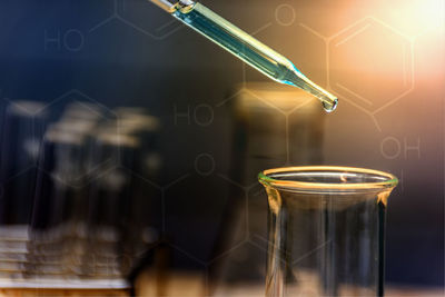 Digital composite image of pipette over laboratory glassware