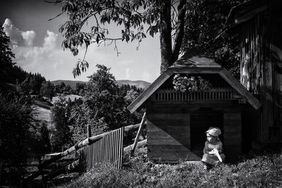 Girl sitting outside doghouse