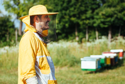 Side view of man wearing hat standing on field