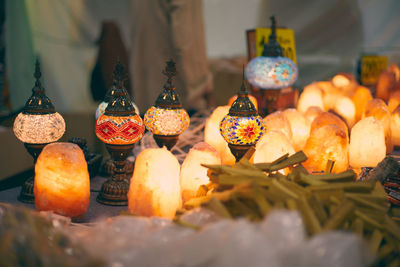 Close-up of salt lamps and colorful lamps on table