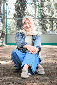 Portrait of a smiling young woman sitting outdoors