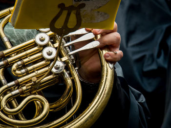 Cropped image of person playing french horn