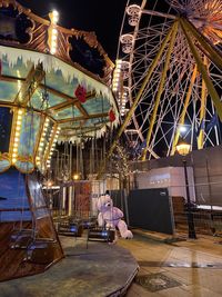 Rear view of woman sitting on amusement park ride at night