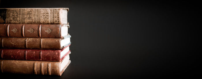 Close-up of stack of books against black background