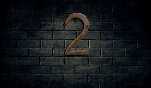 Number 2 on brick wall at night
