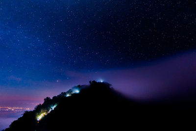 Low angle view of silhouette mountain against sky at night