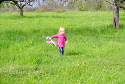 Rear view of woman standing on grassy field