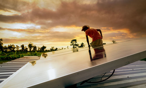 Man checking solar panel on roof for safety. solar panel or photovoltaic module maintenance. 