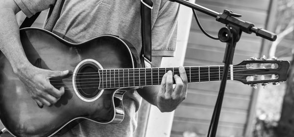 Midsection of man playing guitar