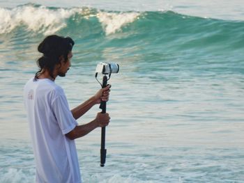 Rear view of man photographing sea