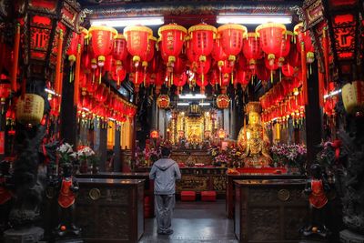 Rear view of illuminated lanterns in temple