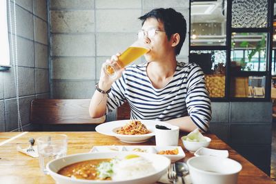 Man drinking beer while having lunch in restaurant