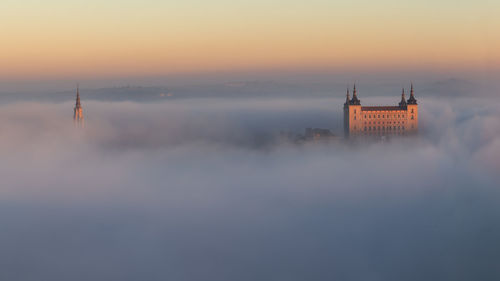 Aerial view of building against cloudy sky during sunset