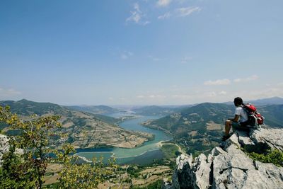 Man looking at mountains against sky