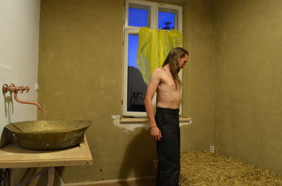 Side view of young man looking at camera